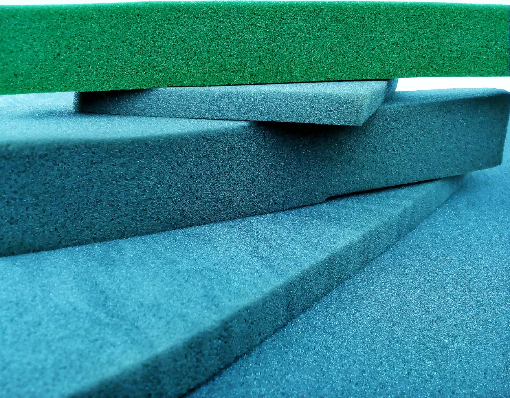 piles of pastel blue and green sponge foam sheet materials of different thicknesses are arranged crosswise